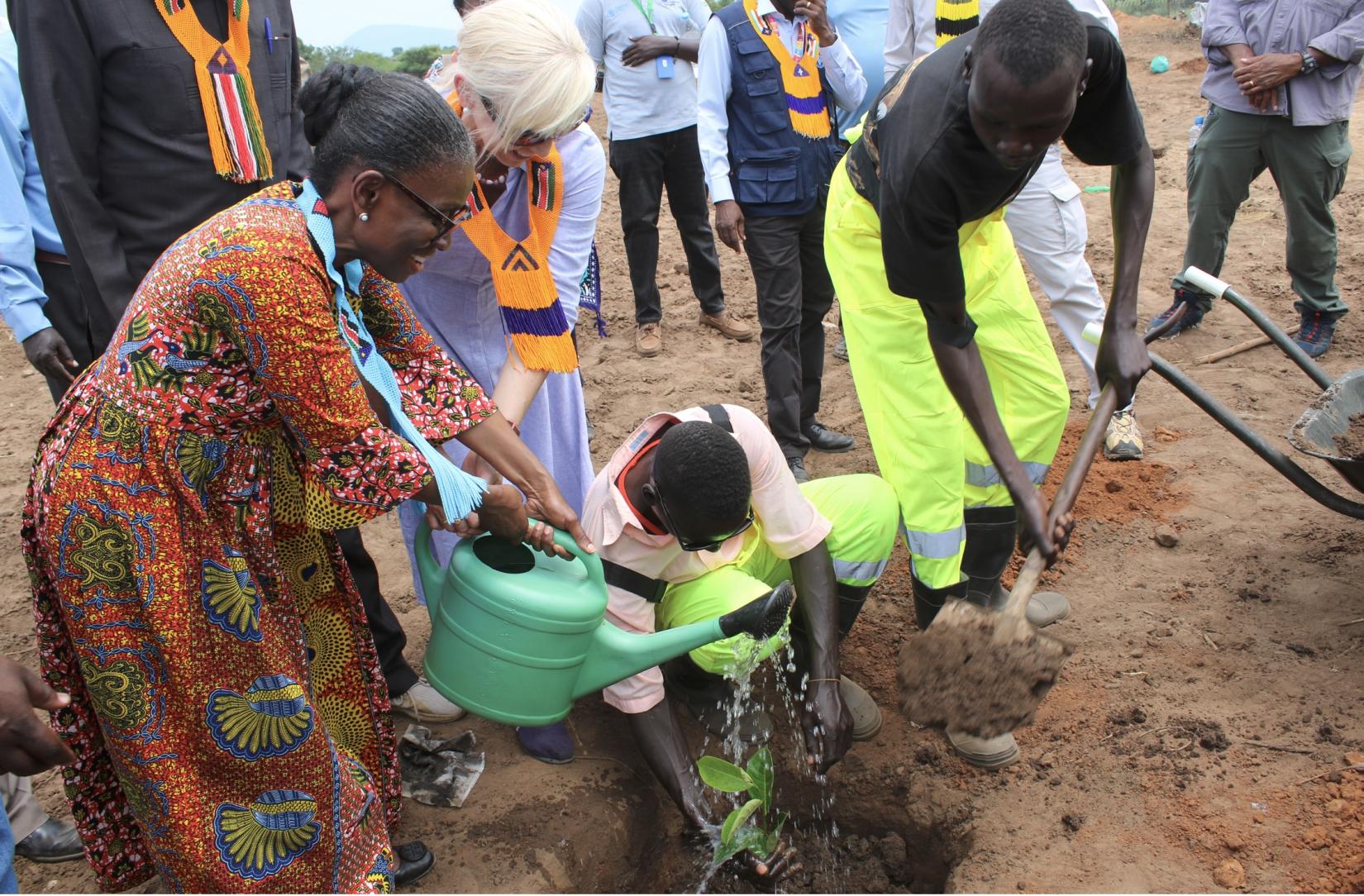 Deputy Special Representative of the Secretary General, Resident Coordinator and Humanitarian Coordinator (in front) and the outgoing Norwegian Ambassador (behind holding watercan) to South Sudan plant a tree, demonstrating the urgent need to preserve the environment.