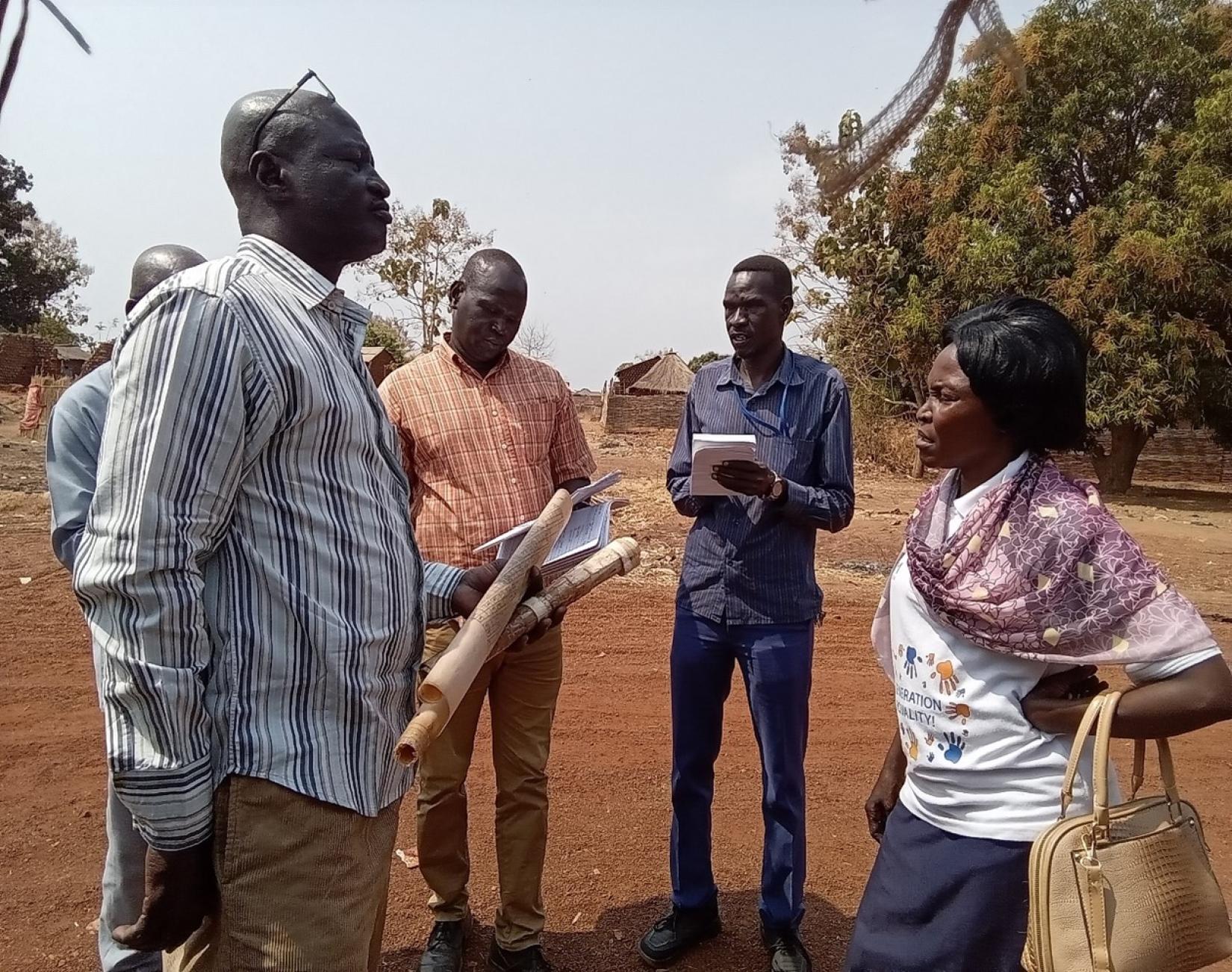 Surveyors from the State Ministry of Housing, Land, and Public Utilities, along with the IOM's HLP team in Wau, verify plot numbers for beneficiaries at Lokloko residential area