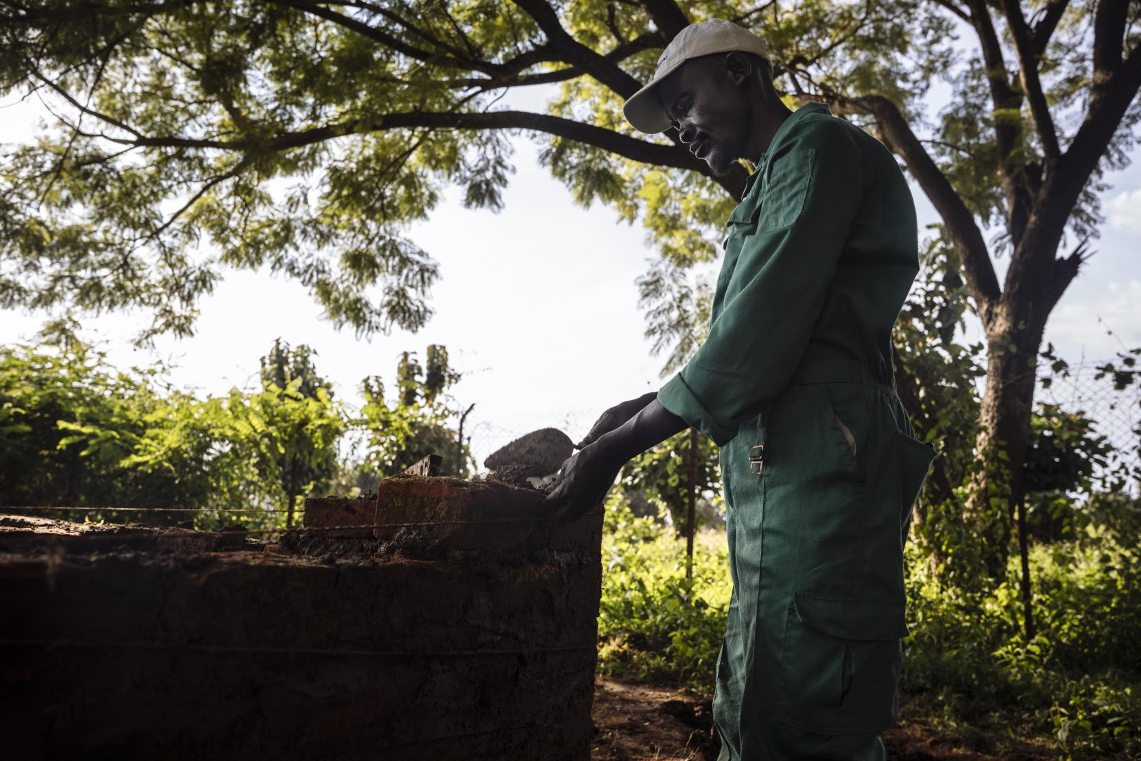 Joel John, a father of five in Yei, rebuilds his life through carpentry skills learned in vocational training provided by IOM—turning hardship into hope while navigating the challenges of post-conflict South Sudan.