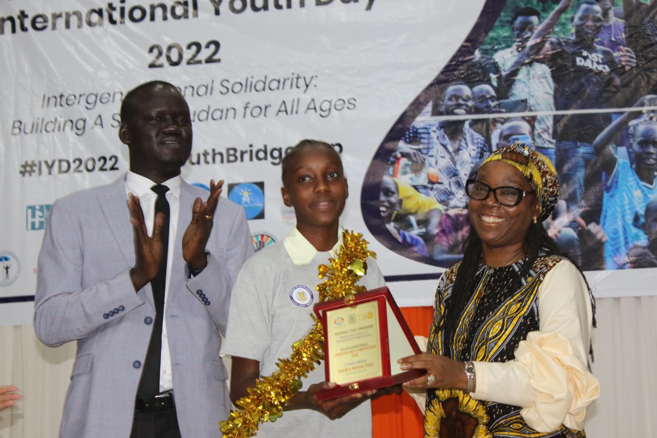 DSRSG/RC/HC Sara Beysolow Nyanti presents an award to one of the winners 