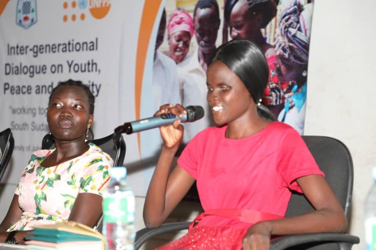 Precious Speaking at the intergenerational dialogue on Youth, Peace and Security as Anna Maneno looks on.