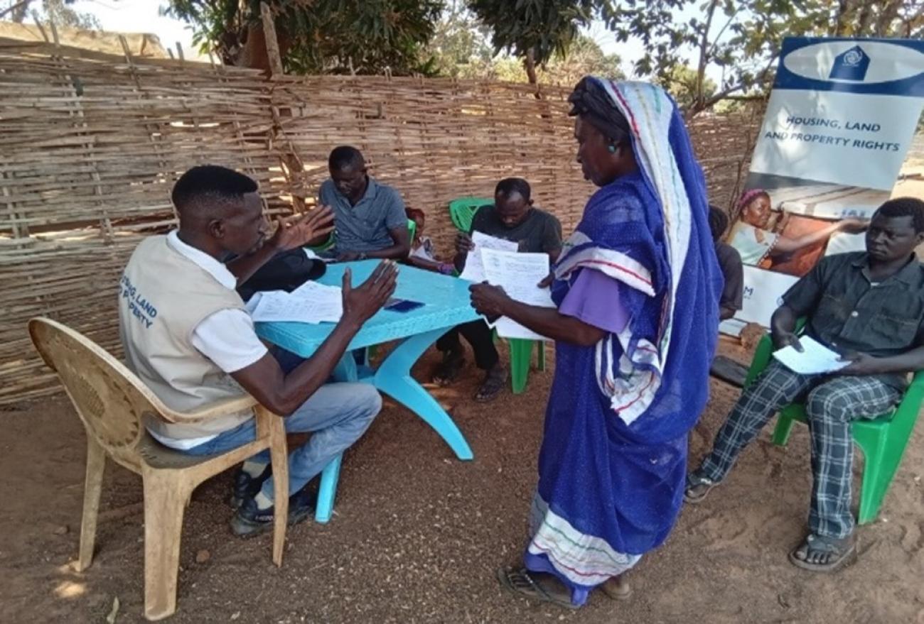 Beneficiaries verifying land documents with Housing Land and Property staff at Hai Jezira Residential Area, Wau. ©IOM/2024