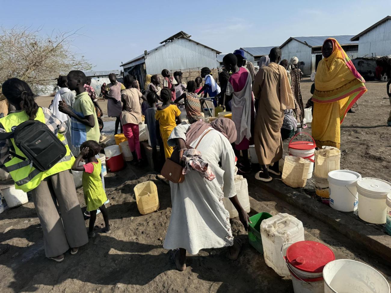 Women and children collect safe drinking water piped from the Nile through IOM’s solar-powered system, which provides over 450,000 liters daily to displaced families in Renk.  