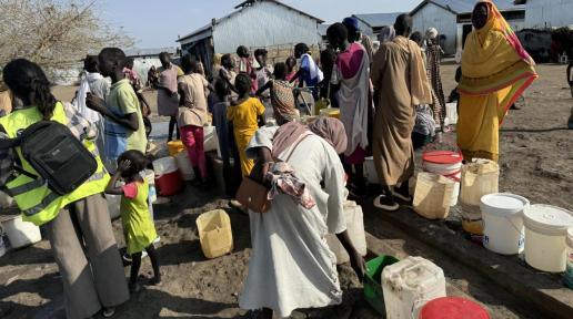 Women and children collect safe drinking water piped from the Nile through IOM’s solar-powered system, which provides over 450,000 liters daily to displaced families in Renk.  