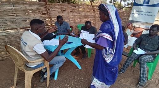 Beneficiaries verifying land documents with Housing Land and Property staff at Hai Jezira Residential Area, Wau. ©IOM/2024